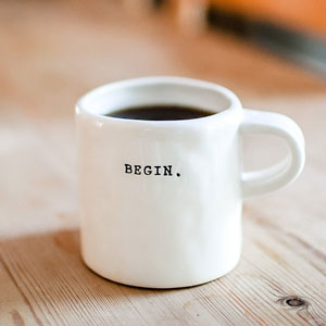 a coffee cup with the phrase begin