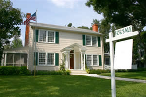 A house with a For Sale sign in front of it